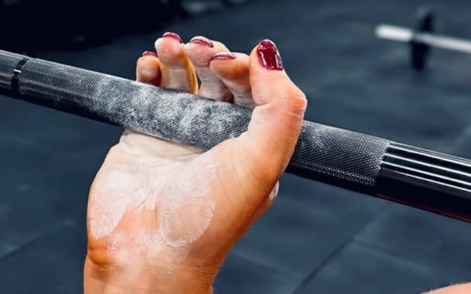 Hands chalked and set on the barbell, the first thing every beginner learns at House of Hybrid.